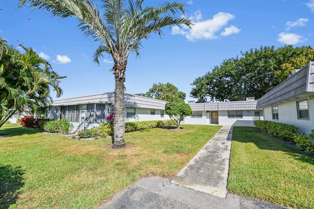 view of front of house featuring a sunroom and a front lawn