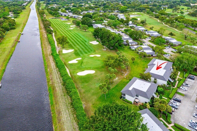 drone / aerial view featuring view of golf course and a water view