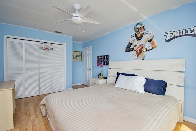 bedroom featuring a closet, visible vents, ceiling fan, and wood finished floors