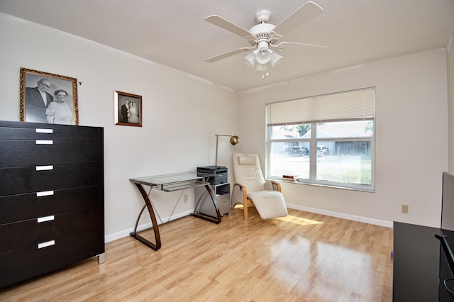 office area with baseboards, light wood finished floors, and ceiling fan