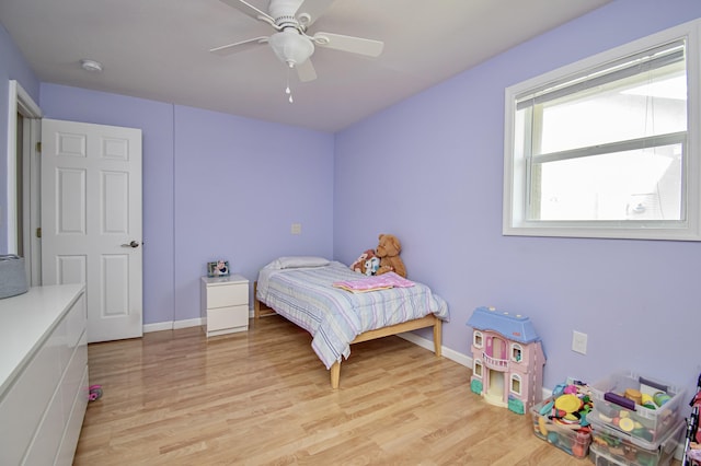 bedroom featuring light wood-style flooring, baseboards, and a ceiling fan