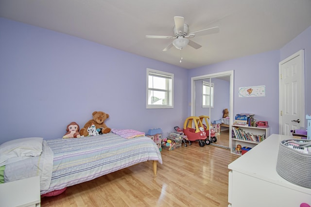 bedroom featuring ceiling fan, a closet, and light wood-style flooring