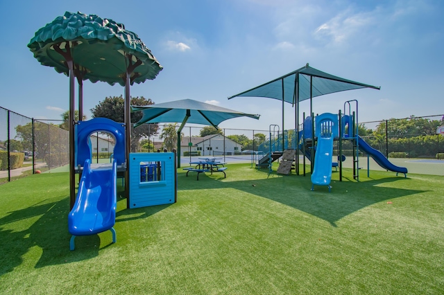 community jungle gym with a yard and fence