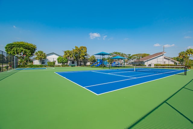 view of tennis court with playground community, community basketball court, and fence