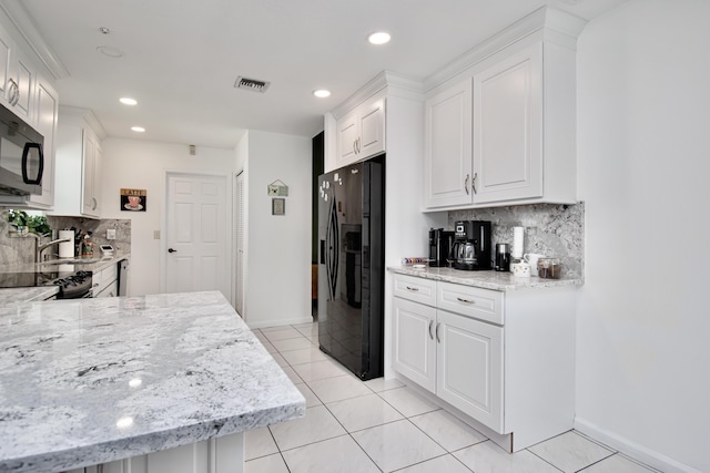 kitchen featuring visible vents, light stone countertops, light tile patterned floors, white cabinets, and black appliances