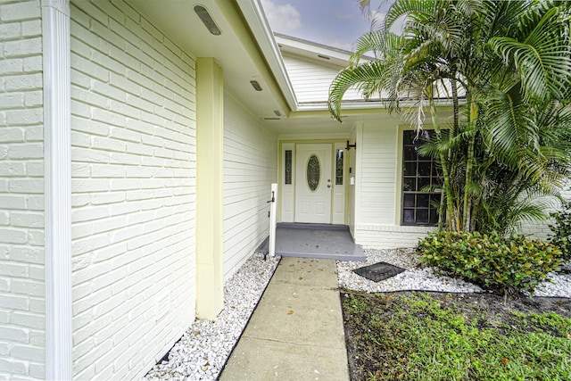 doorway to property with brick siding