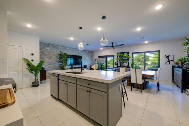 kitchen with visible vents, open floor plan, a sink, gray cabinetry, and stainless steel dishwasher