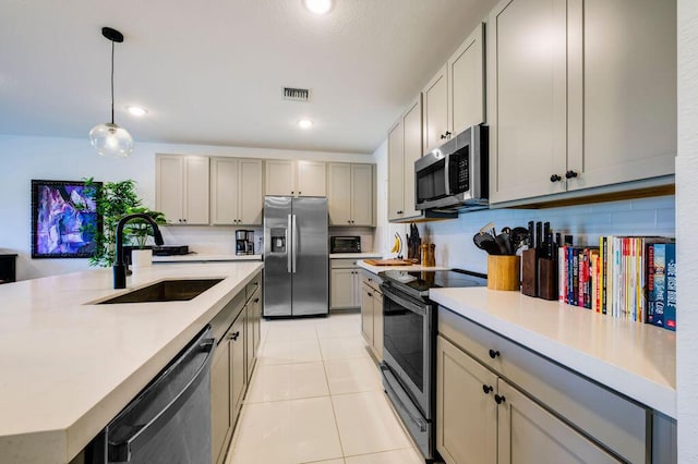 kitchen featuring light tile patterned floors, a sink, visible vents, light countertops, and appliances with stainless steel finishes