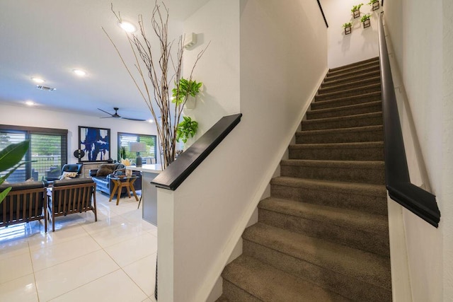 stairs with baseboards, visible vents, a ceiling fan, and tile patterned floors