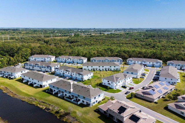 birds eye view of property featuring a forest view, a water view, and a residential view