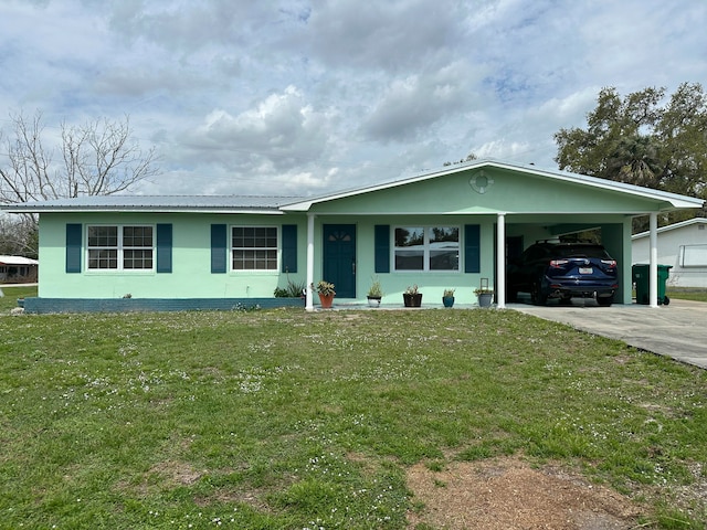 ranch-style home with a carport, metal roof, a front lawn, and concrete driveway