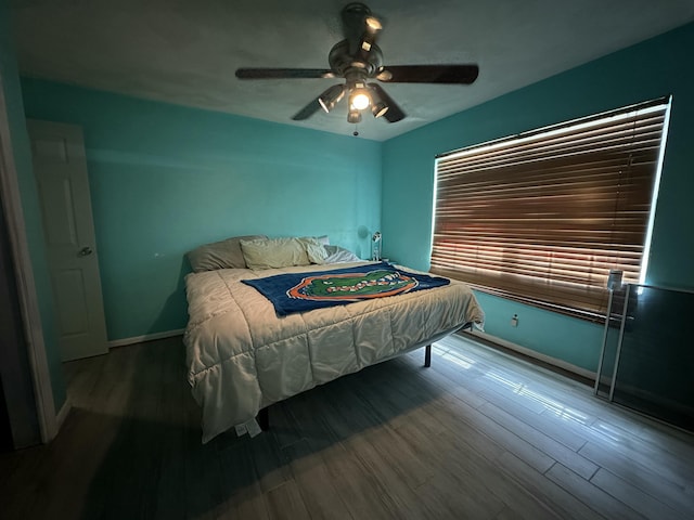 bedroom featuring ceiling fan, baseboards, and wood finished floors