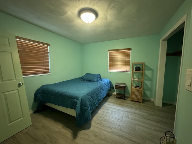 bedroom with wood finished floors and baseboards