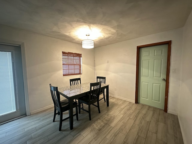 dining area featuring baseboards and wood finished floors