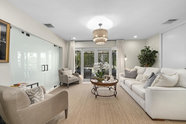 living room featuring a textured ceiling, visible vents, and recessed lighting