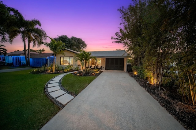 ranch-style home featuring a garage, driveway, and a front yard