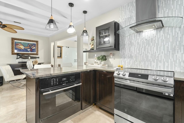 kitchen with stainless steel electric stove, black oven, dark brown cabinets, light stone countertops, and wall chimney exhaust hood