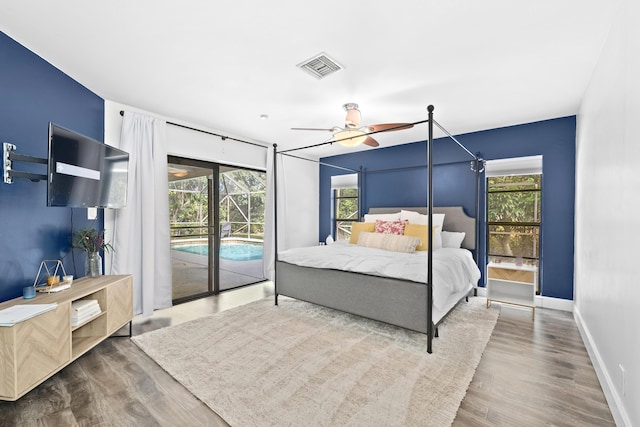 bedroom with access to outside, visible vents, baseboards, and wood finished floors