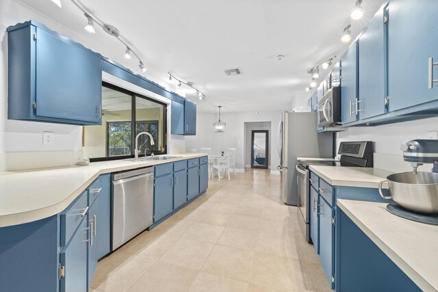 kitchen with stainless steel appliances, blue cabinets, a sink, and visible vents