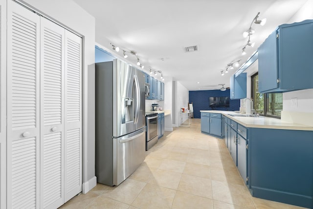 kitchen featuring blue cabinets, visible vents, appliances with stainless steel finishes, and a sink