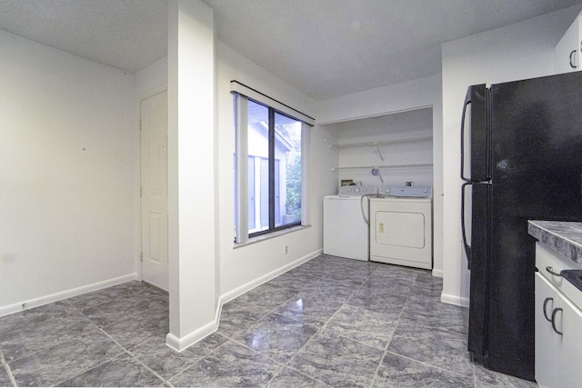 clothes washing area with baseboards and independent washer and dryer