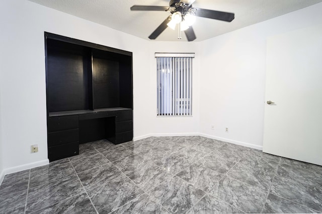 unfurnished bedroom with a ceiling fan, baseboards, and a textured ceiling