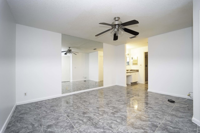 empty room featuring a textured ceiling, visible vents, and baseboards