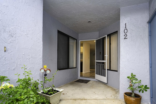 entrance to property featuring a patio area and stucco siding