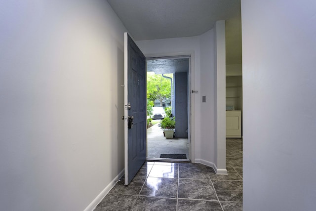 entryway featuring washer / clothes dryer and baseboards