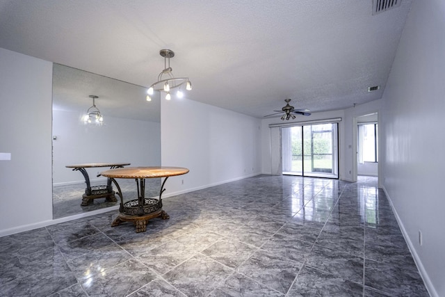 interior space featuring marble finish floor, visible vents, a ceiling fan, a textured ceiling, and baseboards