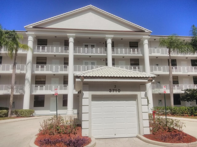 view of property with concrete driveway and a garage