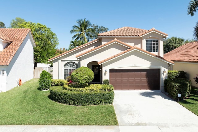 mediterranean / spanish-style home featuring driveway, a garage, a front lawn, and a tiled roof