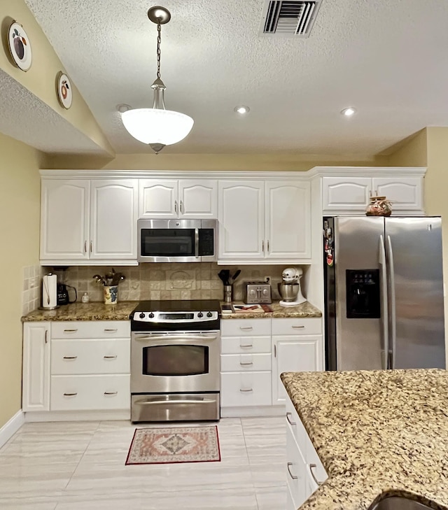 kitchen featuring appliances with stainless steel finishes, light stone countertops, tasteful backsplash, a textured ceiling, and white cabinetry