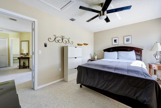 bedroom featuring a textured ceiling, carpet floors, visible vents, and baseboards