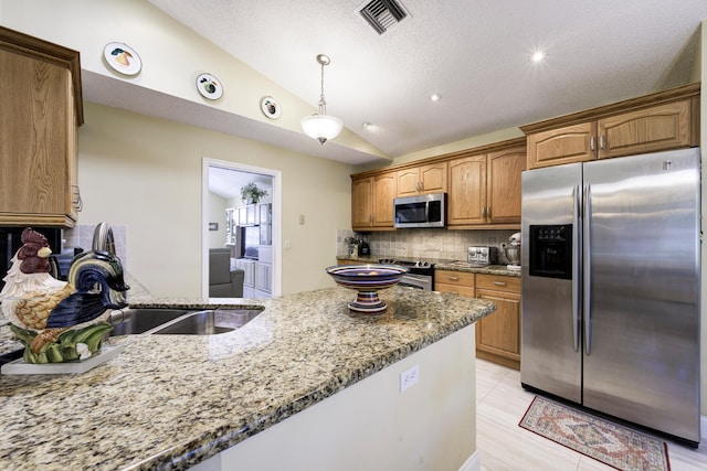 kitchen with visible vents, lofted ceiling, appliances with stainless steel finishes, light stone counters, and backsplash