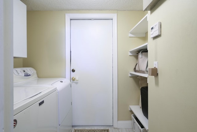 laundry room with independent washer and dryer and a textured ceiling