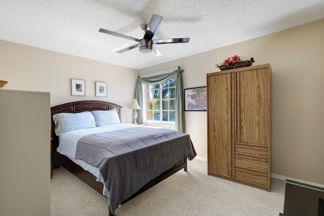 bedroom with light carpet, a textured ceiling, ceiling fan, and baseboards