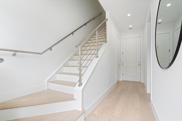 staircase featuring recessed lighting, baseboards, and wood finished floors