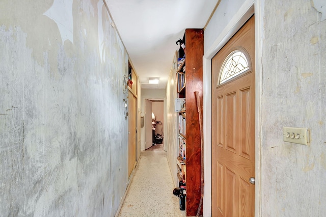 hallway featuring light speckled floor