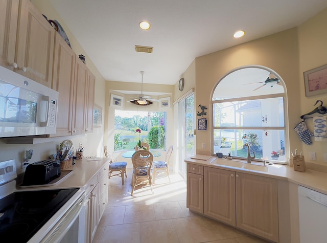 kitchen with visible vents, a sink, white appliances, and light countertops