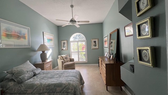 bedroom featuring tile patterned flooring, a textured ceiling, baseboards, and ceiling fan