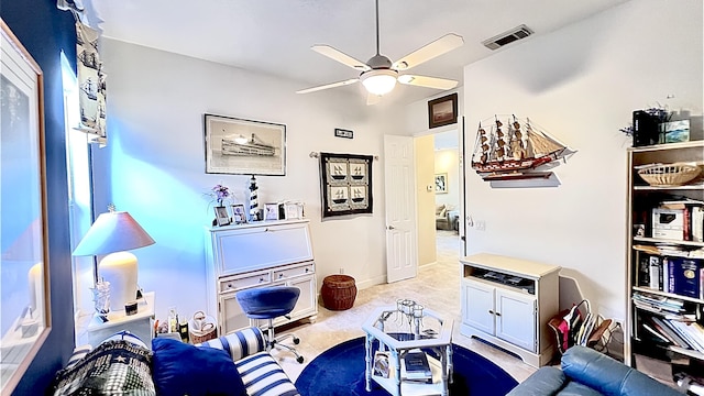 living area with a ceiling fan and visible vents