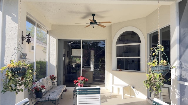 exterior space with a ceiling fan and stucco siding