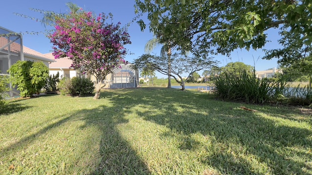 view of yard with a water view and a lanai