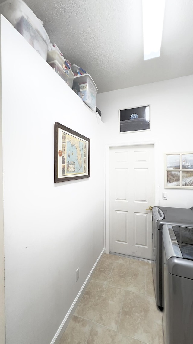 clothes washing area featuring baseboards, laundry area, and washer and clothes dryer