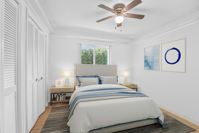 bedroom with ceiling fan, light wood-type flooring, and baseboards