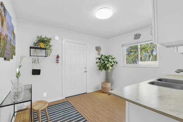 foyer featuring light wood-style flooring and baseboards