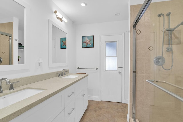 bathroom with double vanity, a shower stall, and a sink