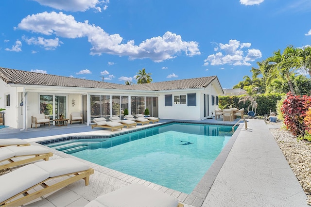 outdoor pool with outdoor lounge area and a patio