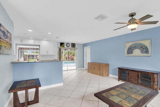 kitchen with light tile patterned floors, built in refrigerator, visible vents, white cabinetry, and decorative backsplash